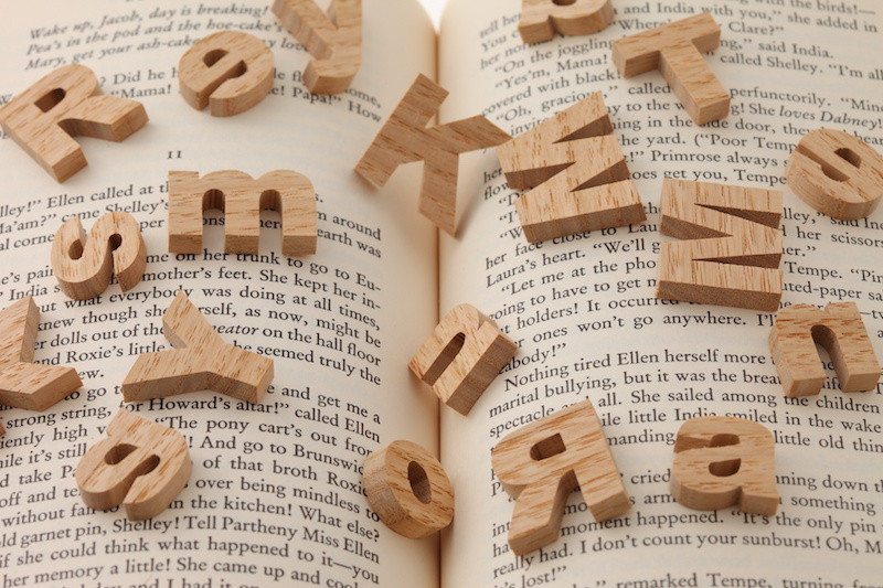 本の上に散乱したアルファベットのブロック